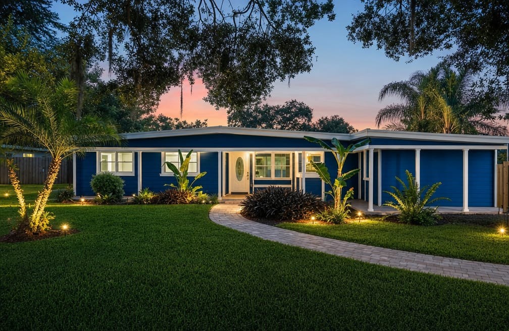 The Sanford residence at twilight, a single-storey home with landscape lighting and a paver walkway